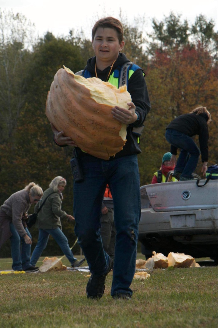 Vlade Sherrill holding a piece of a giant pumpkin at Damariscotta Pumpkinfest